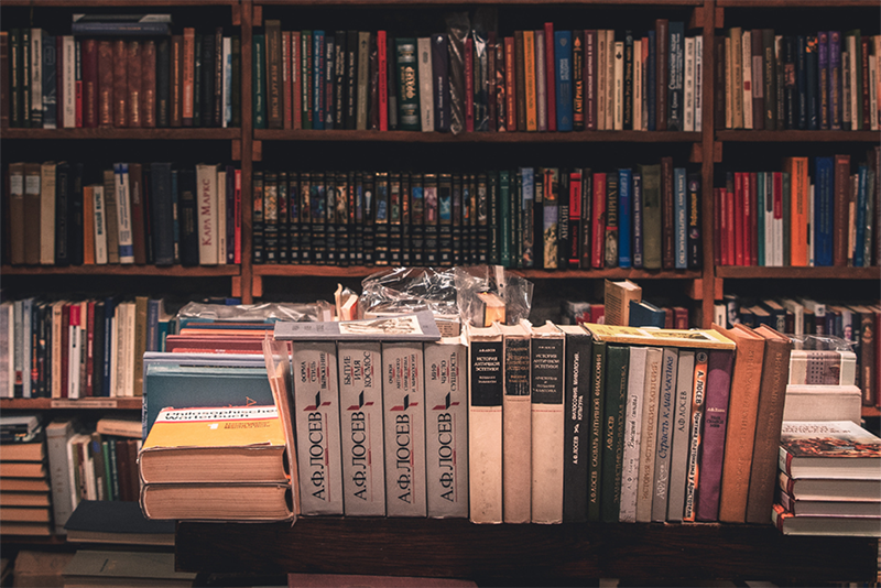a bookshelf filled with lots of books in a library.