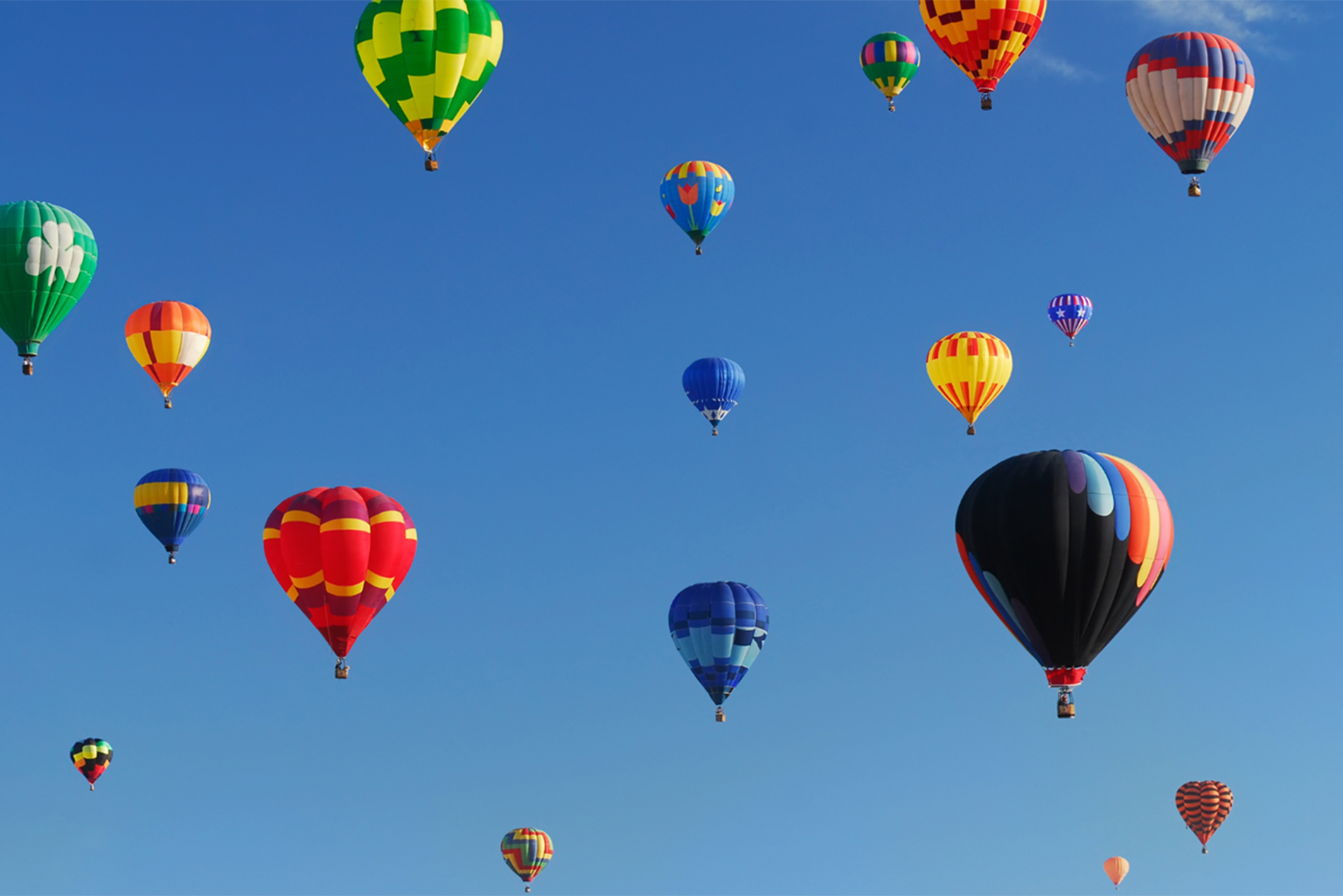 a bunch of hot air balloons flying in the sky.
