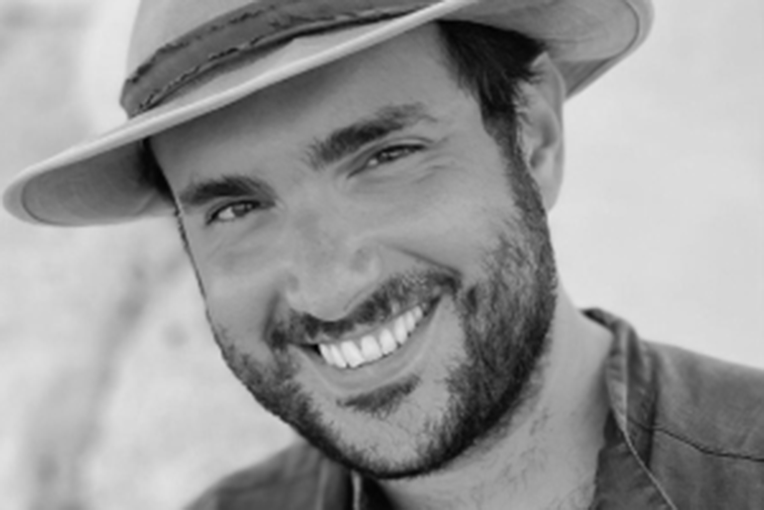 a black and white photo of a man wearing a hat.